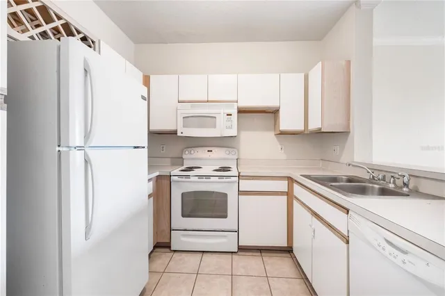 a kitchen with a refrigerator sink stove and cabinets