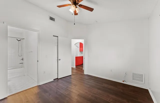 a room with wooden floor and ceiling fan