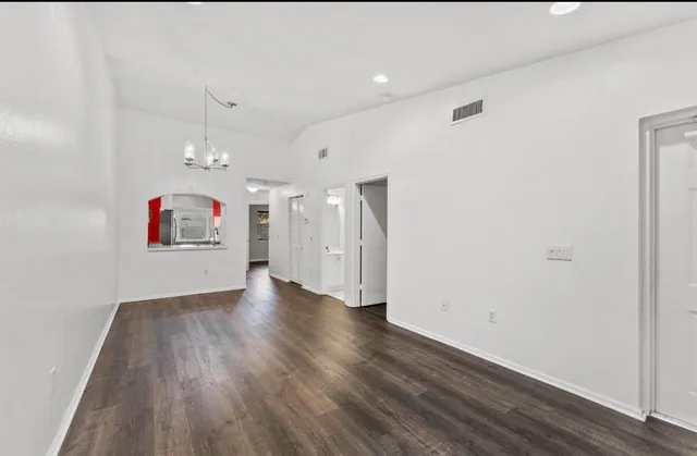 an empty room with wooden floor and white walls
