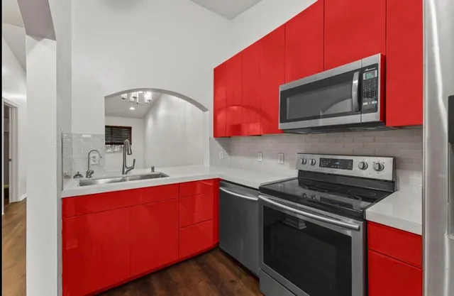 a kitchen with stainless steel appliances a sink microwave and stove