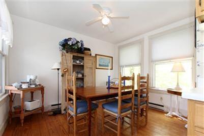 8 Cliff Road, Unit C Nantucket, MA 02554 - Photo 8 of 12 a view of a dining room with furniture and chandelier