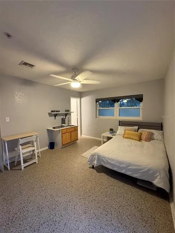 a bedroom with a bed and a refrigerator