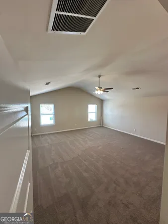 en empty room with windows and ceiling fan