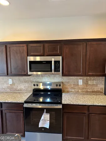 a kitchen with stainless steel appliances granite countertop a sink and a microwave