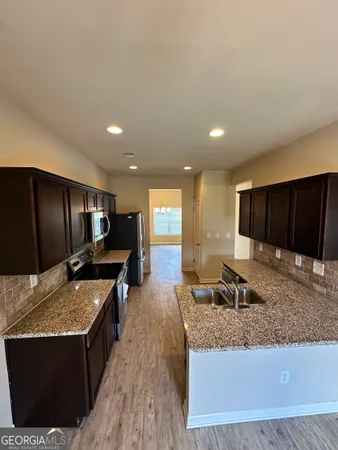 a kitchen with stainless steel appliances granite countertop a stove a sink and a refrigerator