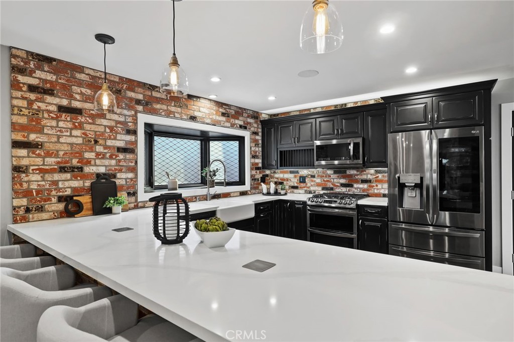 1810 Tanager Drive Costa Mesa, CA 92626 - Photo 16 of 55 a kitchen with stainless steel appliances kitchen island granite countertop a sink and cabinets