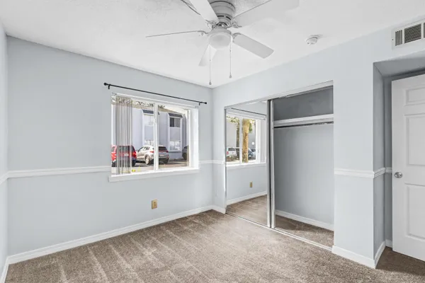 a view of a livingroom with wooden floor and a ceiling fan