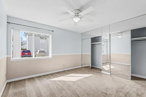 an empty room with windows and fan