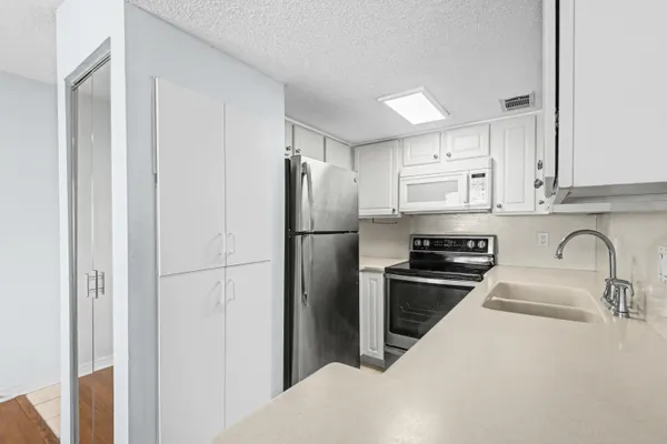 a kitchen with stainless steel appliances granite countertop a refrigerator sink and stove
