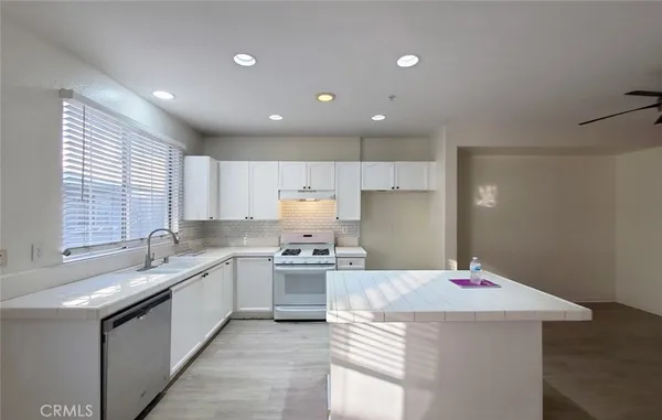 a kitchen with a stove sink and cabinets