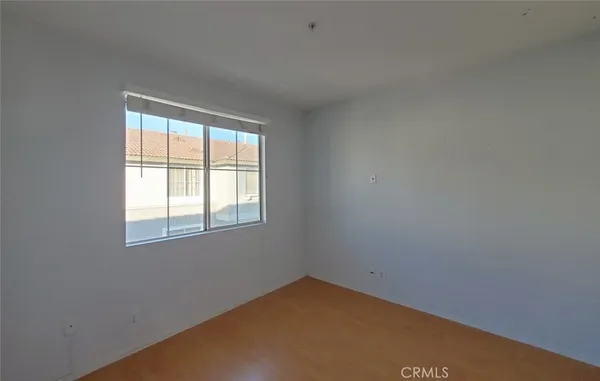 an empty room with chandelier fan and windows