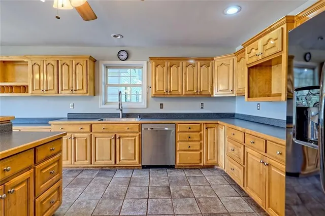 a kitchen with stainless steel appliances granite countertop a refrigerator and a sink