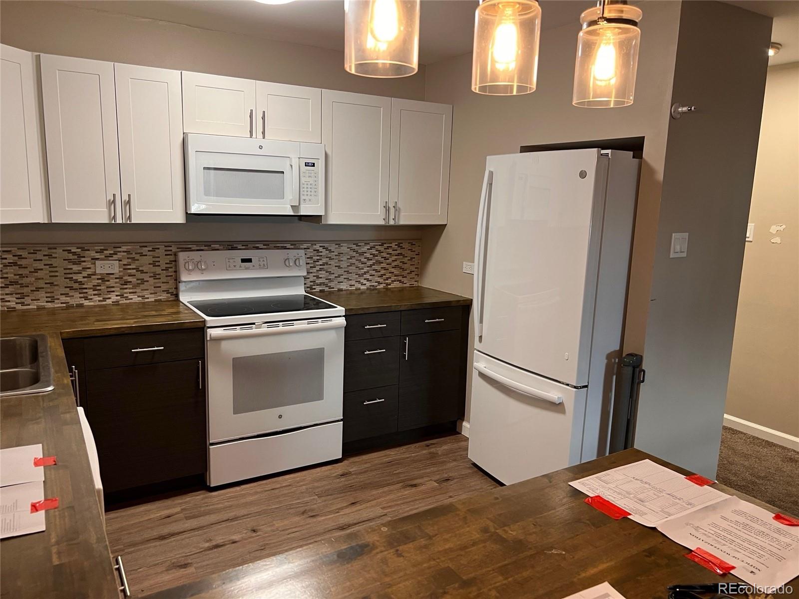 660 South Alton Way, Unit 4A Denver, CO 80247 - Photo 9 of 28 a kitchen with stainless steel appliances a stove a refrigerator and cabinets