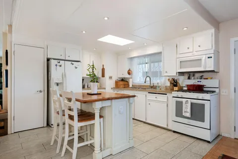 a kitchen with stainless steel appliances granite countertop a white cabinets and a refrigerator
