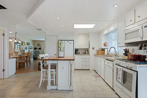 a kitchen with appliances cabinets and chair