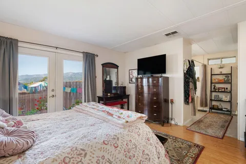 a bed room with a bed a television and a large window