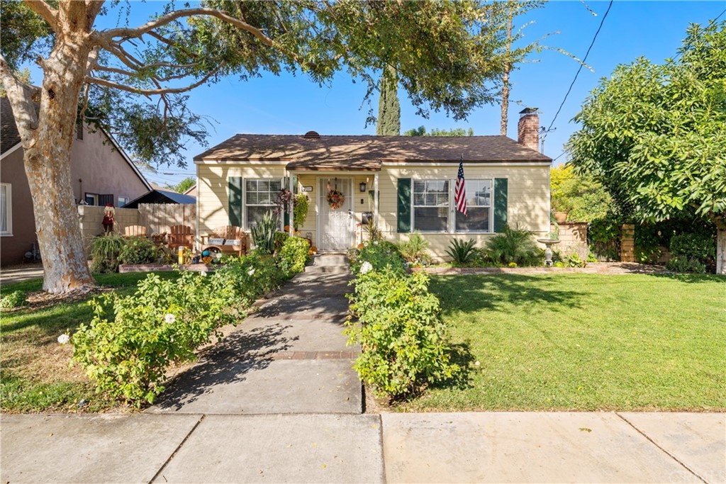 4639 Marmian Way Riverside, CA 92506 - Photo 1 of 1 a view of a white house with a large tree and flower plants