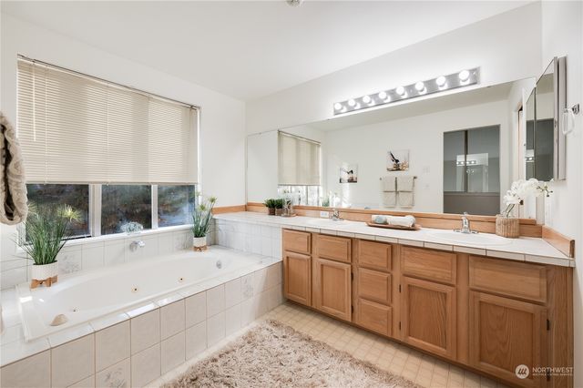 a bathroom with a large tub sink and window