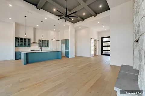 a view of kitchen and empty room with a ceiling fan