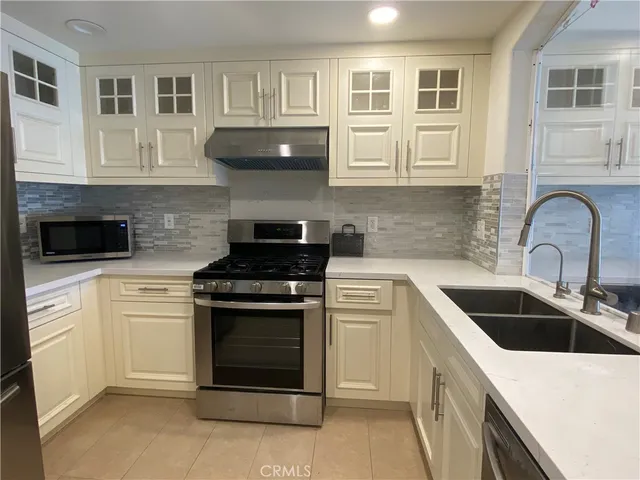 a kitchen with stainless steel appliances granite countertop a stove sink and cabinets