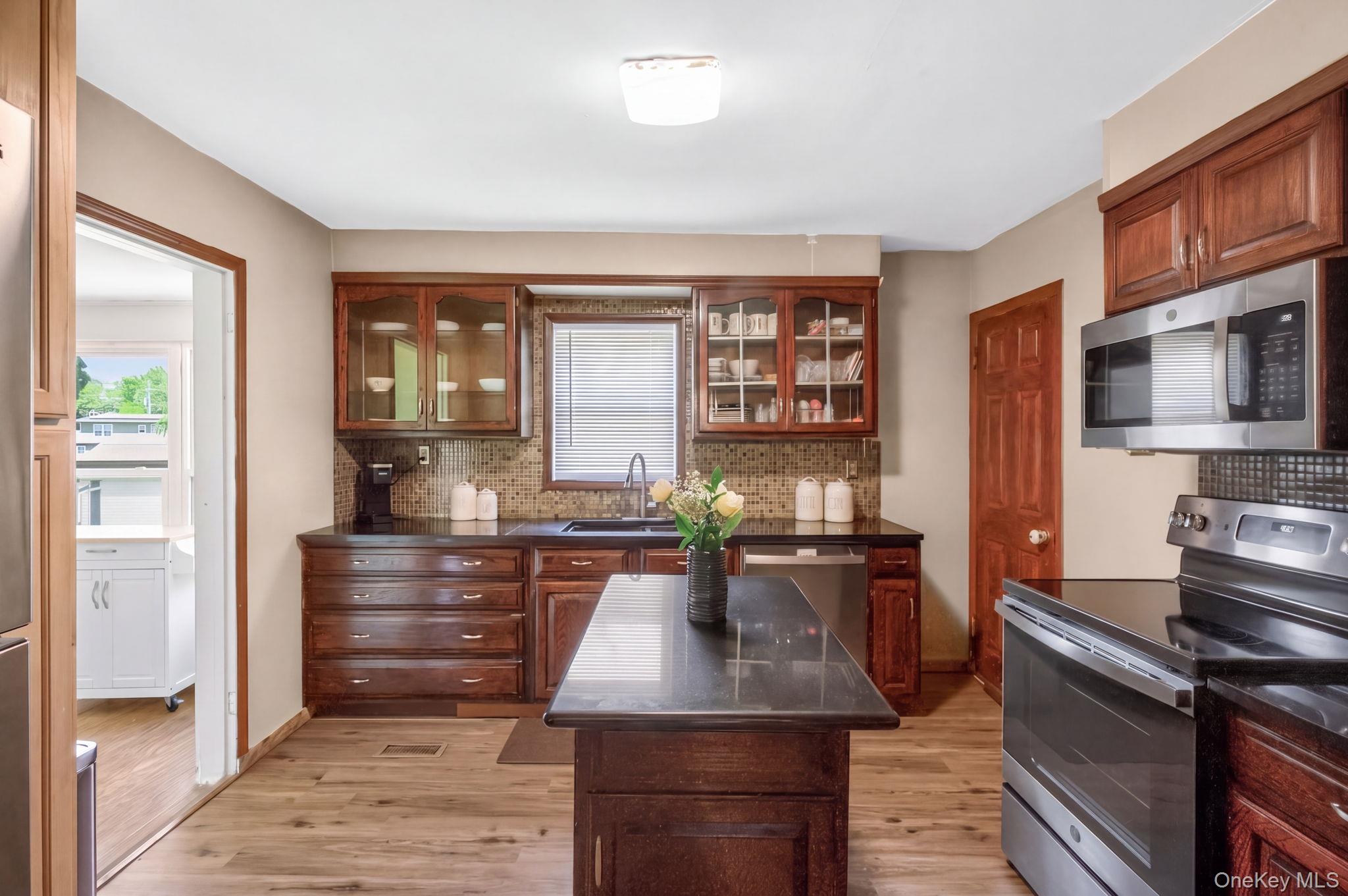 7 Walnut Street Poughkeepsie, NY 12601 - Photo 14 of 30 The kitchen is both stylish and functional, featuring sleek stainless steel appliances, beautiful granite countertops, and a spacious center island that serves as the heart of the room.