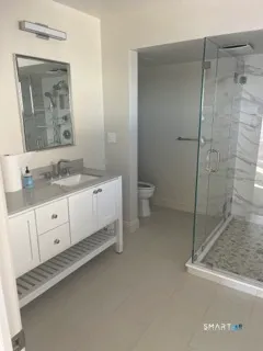 a bathroom with a granite countertop sink mirror and toilet