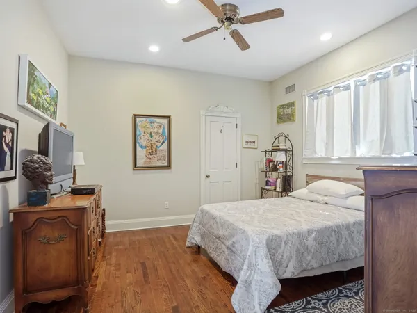 a bedroom with a bed and wooden floor