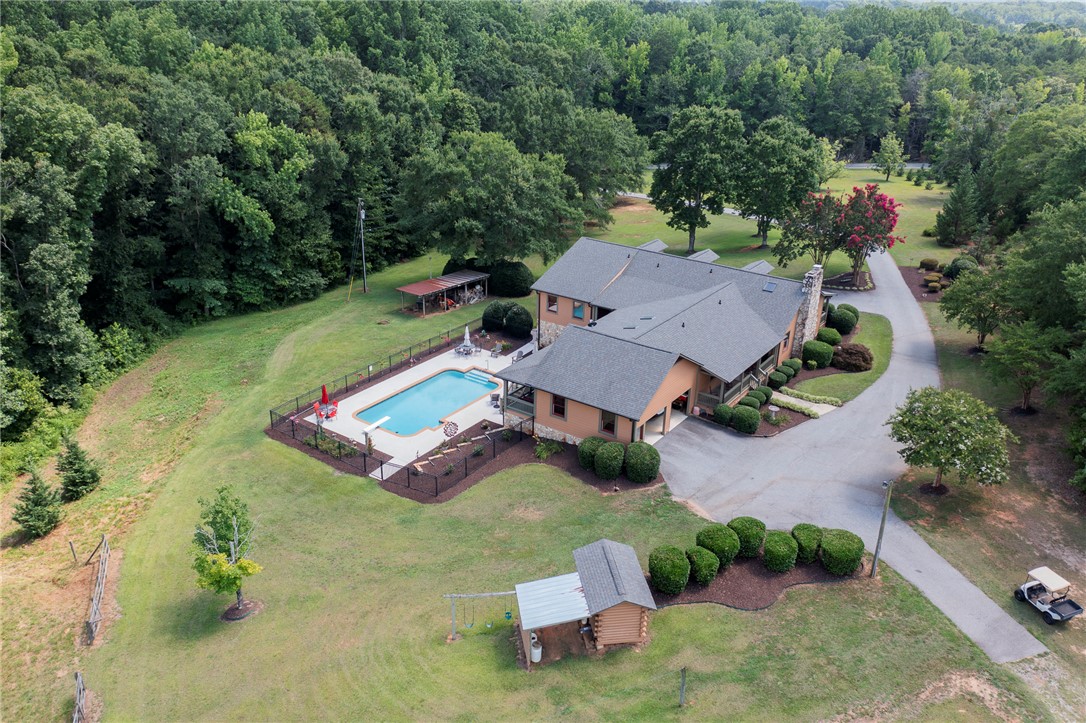 911 State Rd S-4-203 Belton, SC 29627 - Photo 2 of 49 A private wooded setting offers a resort-like backyard with an inviting swimming pool and ample green space.