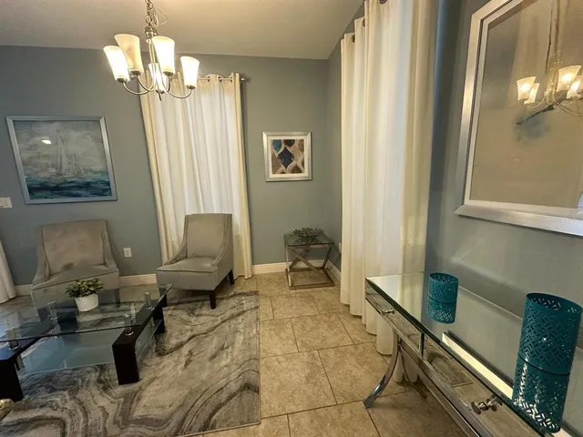 a living room with furniture and a chandelier