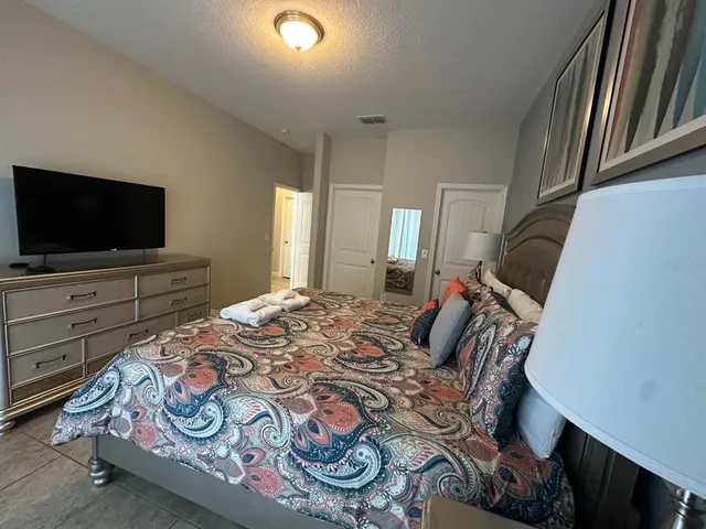 a bedroom with a bed and flat screen tv