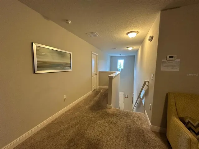 a view of a hallway with paintings on the wall