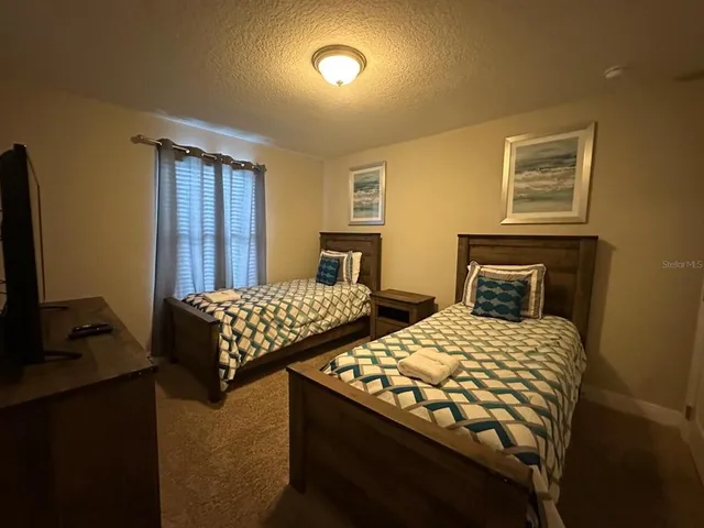 a bedroom with two beds and a desk