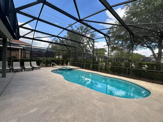 a view of a swimming pool with a patio and a yard