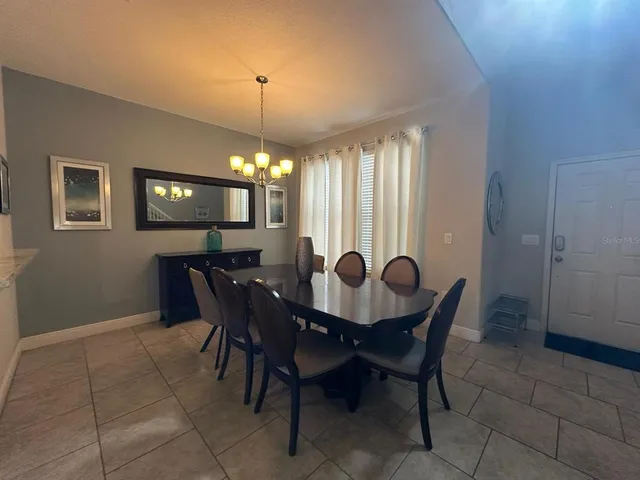a view of a dining room with furniture and chandelier