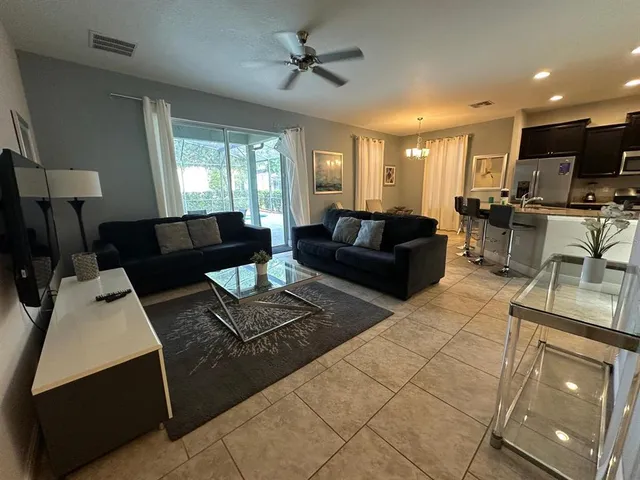 a living room with furniture a ceiling fan and a window