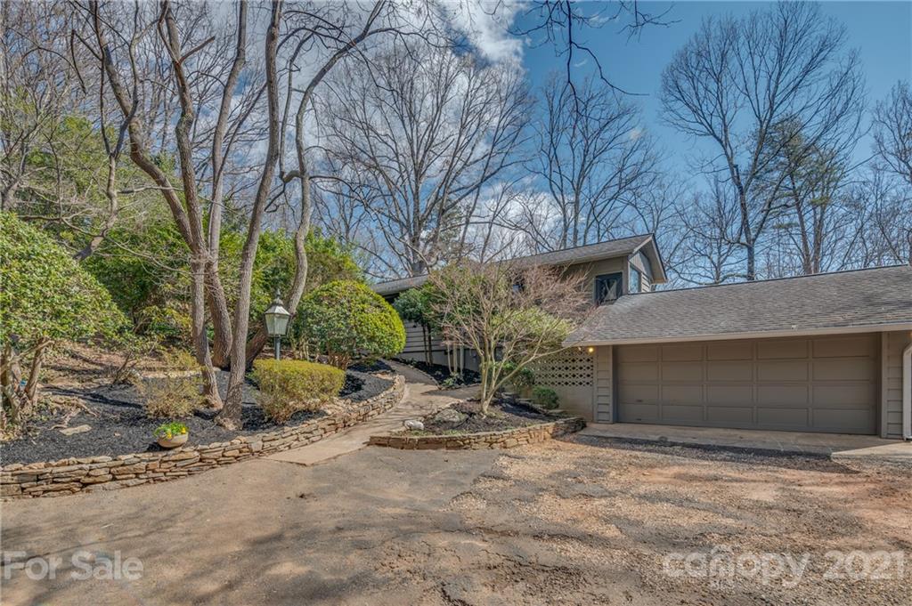 172 Wilderness Road Tryon, NC 28782 - Photo 1 of 46 a pathway of a house with a yard and garage