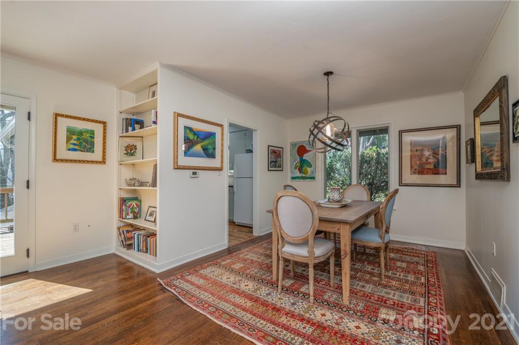 172 Wilderness Road Tryon, NC 28782 - Photo 15 of 46 a dining room with wooden floor a chandelier a wooden table and chair