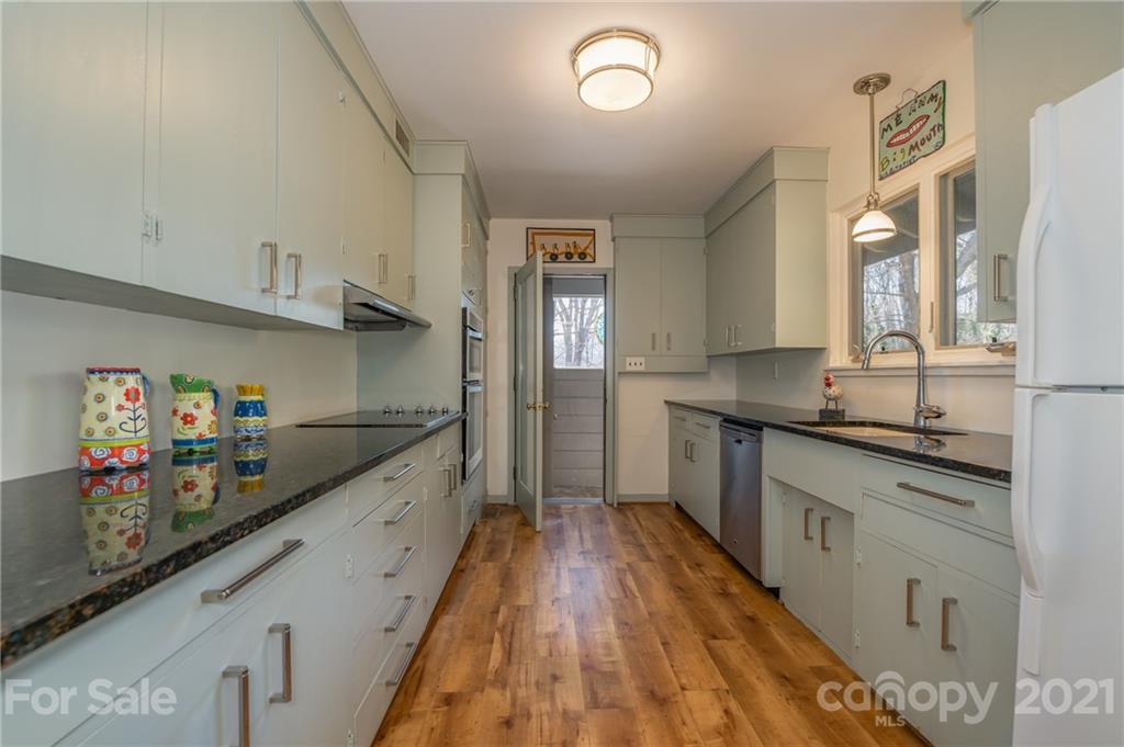 172 Wilderness Road Tryon, NC 28782 - Photo 16 of 46 a large kitchen with stainless steel appliances granite countertop a lot of counter space and wooden floor