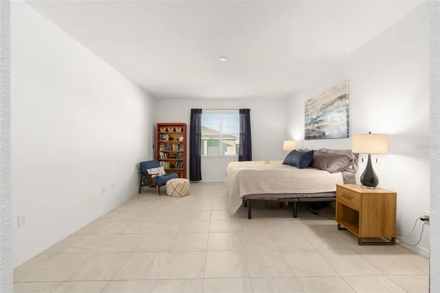 a spacious bedroom with a bed and a table