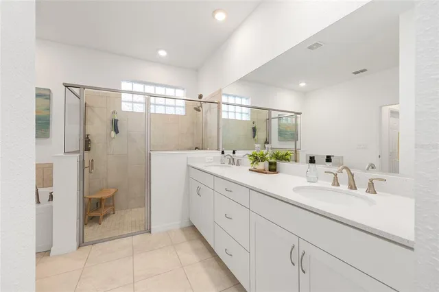 a bathroom with a double vanity sink toilet and shower