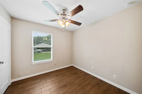 an empty room with windows and fan