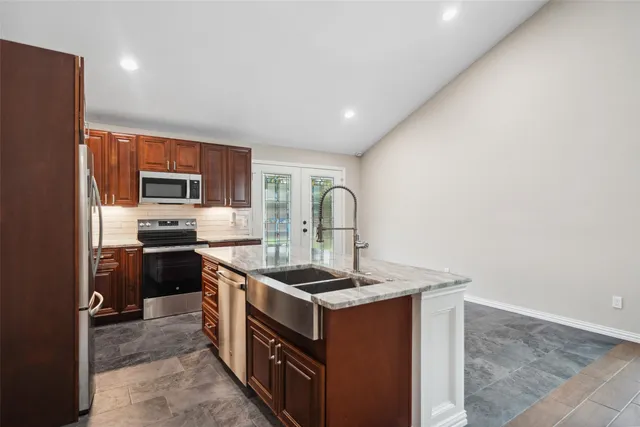 a kitchen that has a sink cabinets stainless steel appliances and a counter top space
