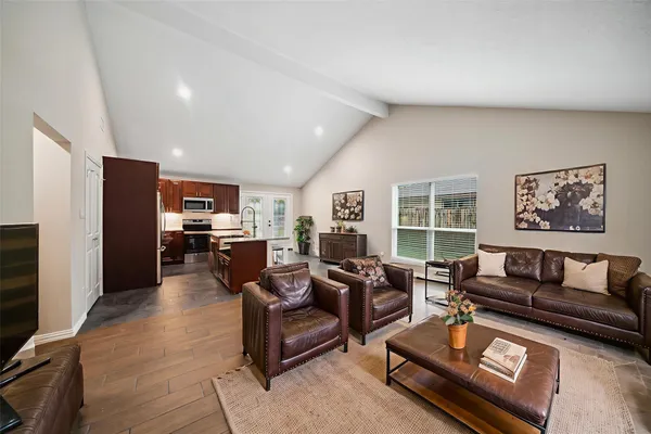 a living room with furniture a large window and kitchen view