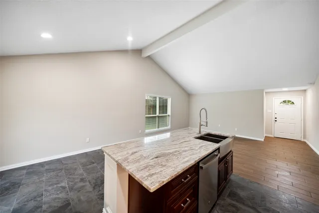 an empty room with kitchen appliances and wooden floor