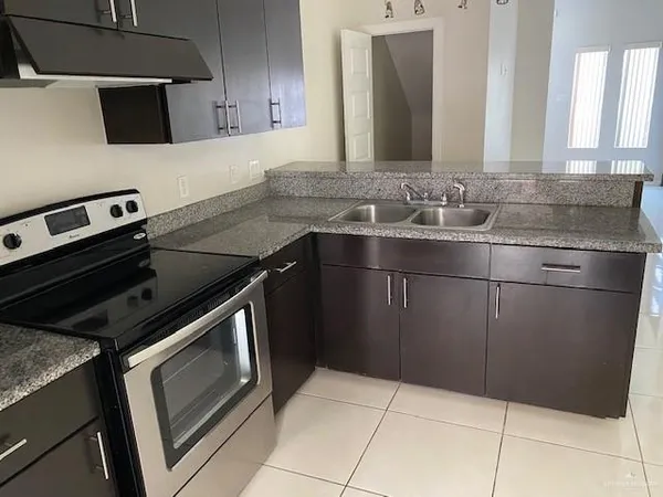 a kitchen with kitchen island granite countertop a sink and a stove