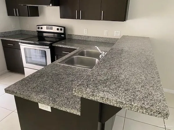 a kitchen with stainless steel appliances a refrigerator and a counter top space