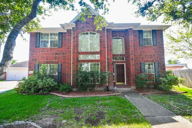 front view of a brick house with a yard