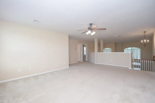 a view of a room with a ceiling fan and window