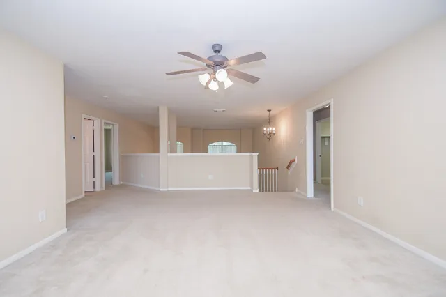 a view of a big room with a ceiling fan and a bathroom