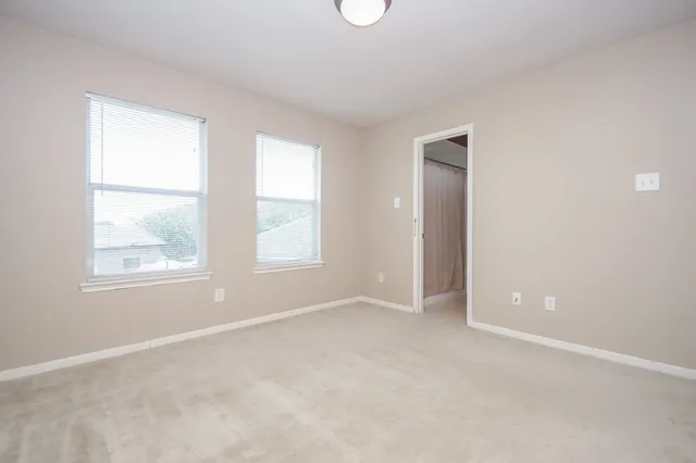 an empty room with windows and closet